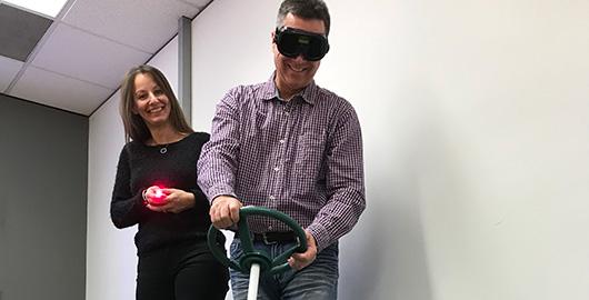 Un participant essaie de faire un parcours avec des lunettes qui simulent l’effet du cannabis, pendant qu’une animatrice le surveille.